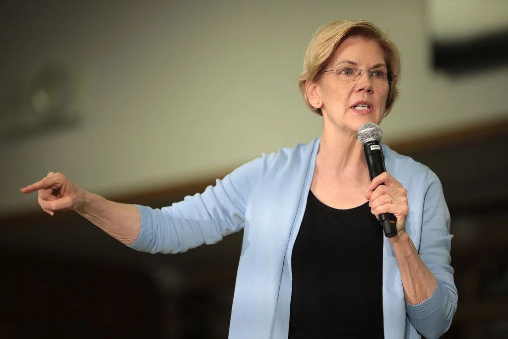 Image of Senator Elizabeth Warren wearing grey shirt and holding mic