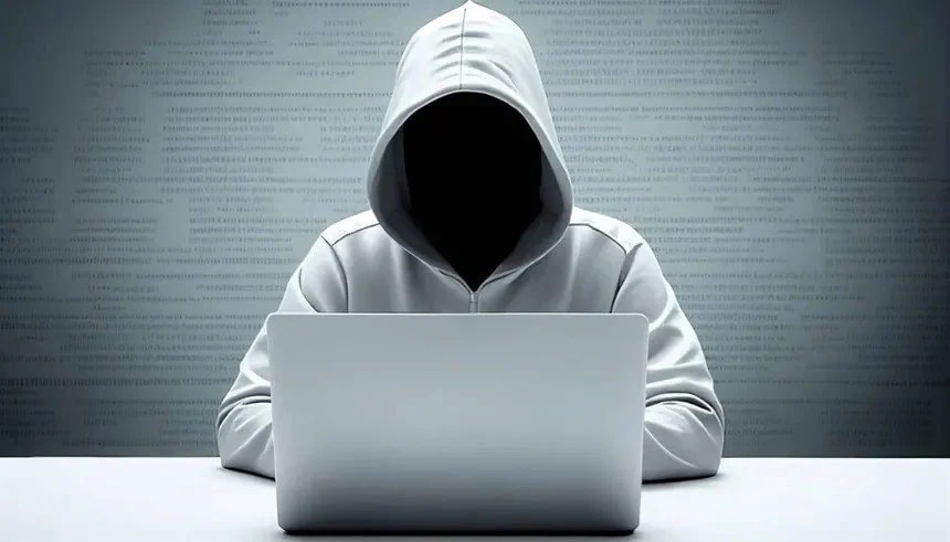 Image of a hacker without face doing something on his laptop