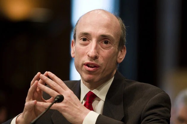 Image of Gary Gensler wearing coat and white shirt with red tie
