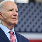 Joe Biden standing in front of US Flag
