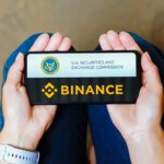 Binance and The SEC logo in a phone